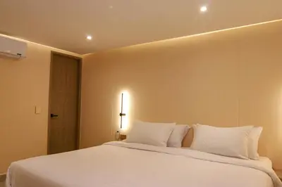 a bedroom with a large white bed with white pillows at Dunia Suite in Cartagena de Indias