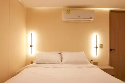 a bedroom with a white bed with two lights at Dunia Suite in Cartagena de Indias