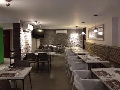a restaurant with white tables and chairs and a brick wall at Dunia Suite in Cartagena de Indias