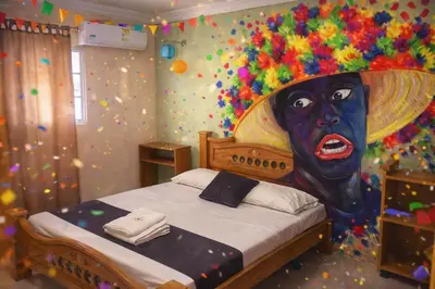 a bedroom with a bed with a painting of a woman at Hotel Georgina in Barranquilla