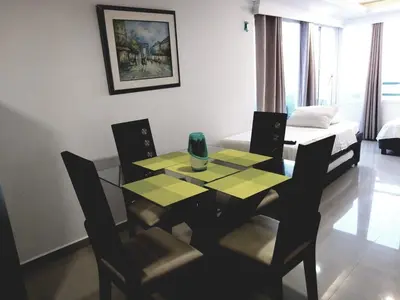 a dining room with a table and chairs and a bed at Apartamento Moderno con Vista - Piso 12 in Cartagena de Indias
