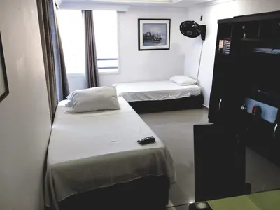 a small room with two beds and a tv at Apartamento Moderno con Vista - Piso 12 in Cartagena de Indias