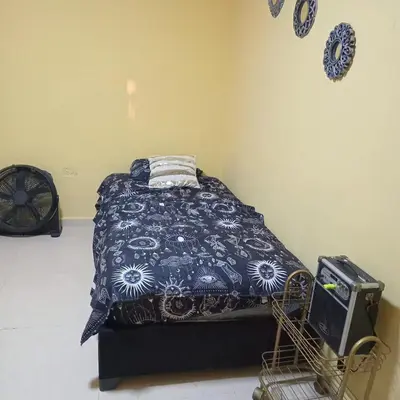 a bedroom with a bed with a blue comforter at comodo apartamento in Barranquilla