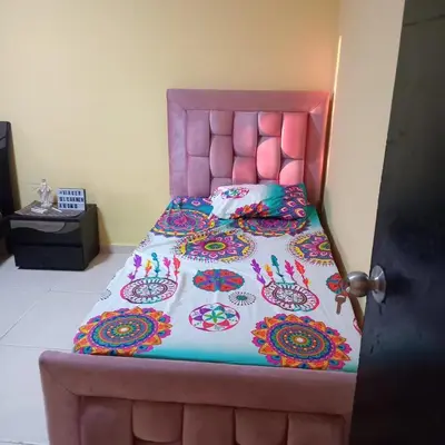 a large bed with a pink headboard in a room at comodo apartamento in Barranquilla
