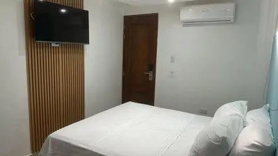 a bedroom with a bed and a flat screen tv at Hotel Boulevard 58 in Galapa