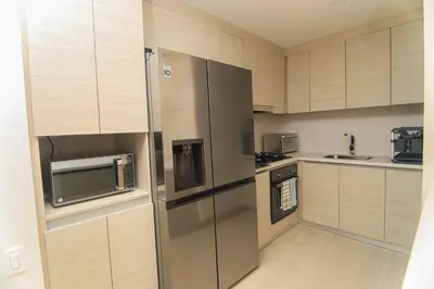 a kitchen with stainless steel appliances and wooden cabinets at Exclusive Apartment With Ocean View By Huespedia in Cartagena de Indias