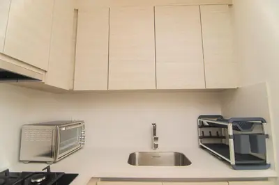 a kitchen with a sink and wooden cabinets at Exclusive Apartment With Ocean View By Huespedia in Cartagena de Indias