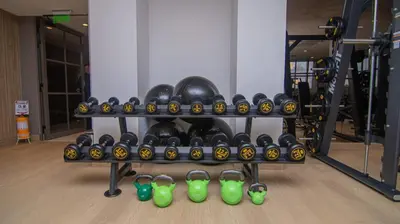 a shelf of dumbbells and green glasses in a gym at Exclusive Apartment With Ocean View By Huespedia in Cartagena de Indias