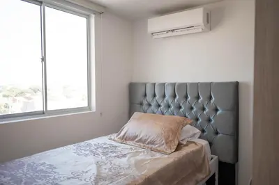 a bedroom with a bed with a large window at Apartamento cerca al aeropuerto in Cartagena de Indias