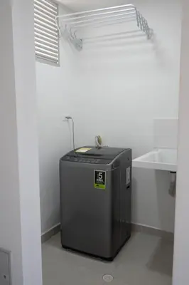 a small refrigerator in a white room with a window at Apartamento cerca al aeropuerto in Cartagena de Indias