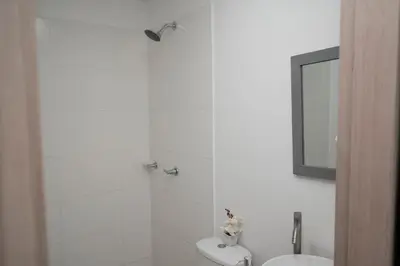 a bathroom with a shower and a toilet and a mirror at Apartamento cerca al aeropuerto in Cartagena de Indias