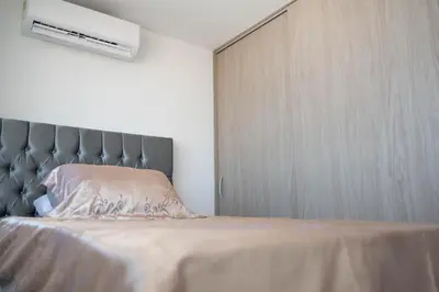a bedroom with a bed with a gray headboard at Apartamento cerca al aeropuerto in Cartagena de Indias