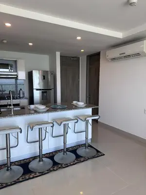 a kitchen with a counter with bar stools at MC 1303- beach front apt- Morros City top location in Cartagena de Indias