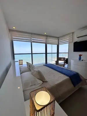 a bedroom with a bed with a view of the ocean at MC 1303- beach front apt- Morros City top location in Cartagena de Indias
