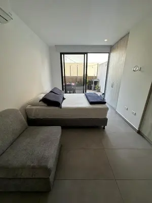 two beds in a room with a couch and a window at Apartamento Arrecife Golf in Barranquilla