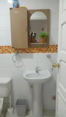 a bathroom with a sink and a mirror and a toilet at Apartaestudio Ciudad Jardin in Barranquilla