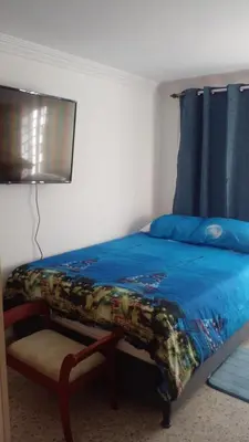 a bedroom with a bed with a blue comforter at Apartaestudio Ciudad Jardin in Barranquilla