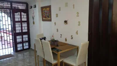 a dining room with a wooden table and white chairs at Apartaestudio Ciudad Jardin in Barranquilla