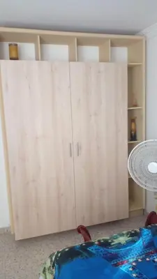 a large wooden cabinet in a room with a table at Apartaestudio Ciudad Jardin in Barranquilla