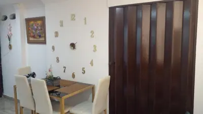 a dining room with a table and a wooden door at Apartaestudio Ciudad Jardin in Barranquilla