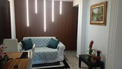 a living room with a chair and a wall at Apartaestudio Ciudad Jardin in Barranquilla