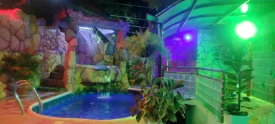 a pool in a room with a rock wall at Cabaña La Makuira in Santa Marta