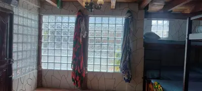 a room with two large windows in a room at Cabaña La Makuira in Santa Marta