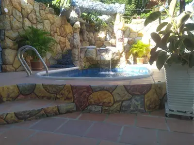 a bath tub with a fountain in a stone wall at Cabaña La Makuira in Santa Marta