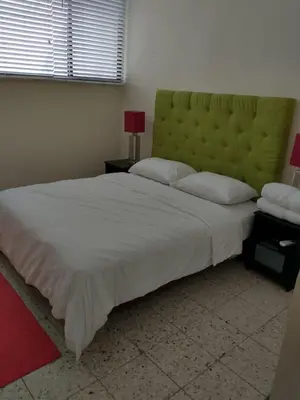 a bedroom with a large bed with a green headboard at Vista al Mar in Cartagena de Indias