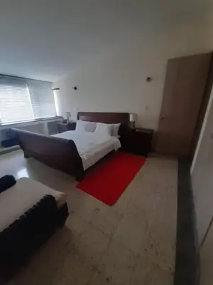 a large bedroom with a bed and a red rug at Vista al Mar in Cartagena de Indias