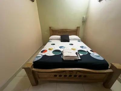 a bedroom with a bed with a black and white comforter at Hotel Don Fermin in Barranquilla
