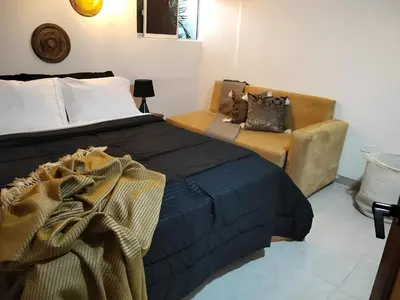 a bedroom with a bed and a chair at Hotel Boutique Tierra Del Mar Cartagena in Cartagena de Indias