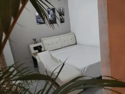 a white bed and a chair in a room at Hotel Boutique Tierra Del Mar Cartagena in Cartagena de Indias