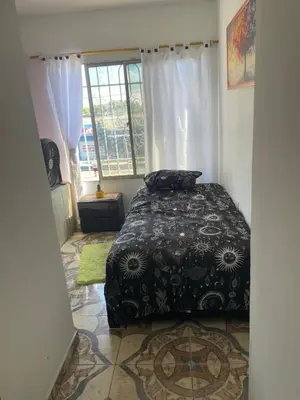 a bedroom with a bed in a room with a window at comodo apartamento in Barranquilla