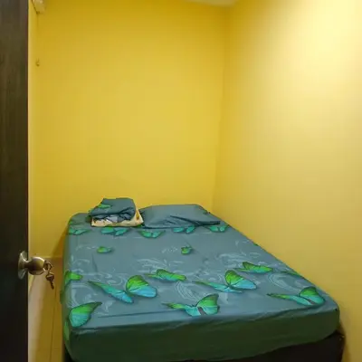 a bed in a corner of a room with a yellow wall at comodo apartamento in Barranquilla