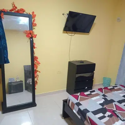a bedroom with a mirror and a bed and a television at comodo apartamento in Barranquilla