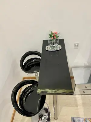 a black table with two glasses and flowers on it at Cartagena Loft Independiente by Tico in Cartagena de Indias