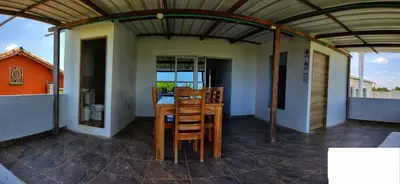 a room with a table and chairs on a balcony at Cabaña doña Santi in San Antero