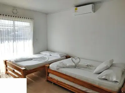 two twin beds in a room with a window at Cabaña doña Santi in San Antero