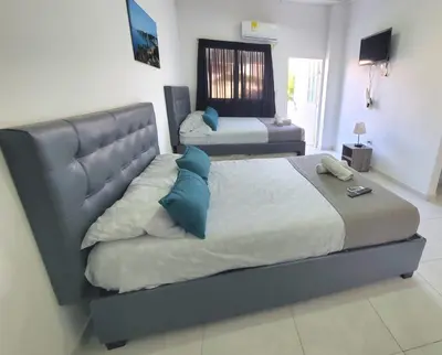 a bedroom with two beds with blue pillows at Apartahotel hm caribe in Santa Marta