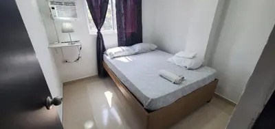 a small bedroom with a bed with towels on it at Apartahotel hm caribe in Santa Marta