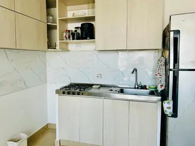 a white kitchen with a sink and a refrigerator at Habitación por día en Cartagena 70 mil in Cartagena de Indias