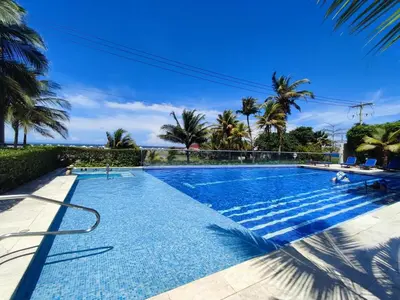 a swimming pool with palm trees and a blue sky at Hermoso Apto playa de Morros! in Cartagena de Indias