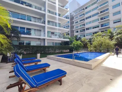 a group of blue lounge chairs next to a swimming pool at Hermoso Apto playa de Morros! in Cartagena de Indias
