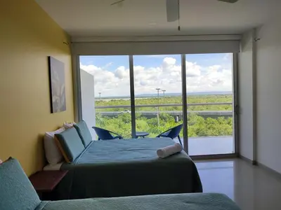 a bedroom with two beds and a large window at Hermoso Apto playa de Morros! in Cartagena de Indias