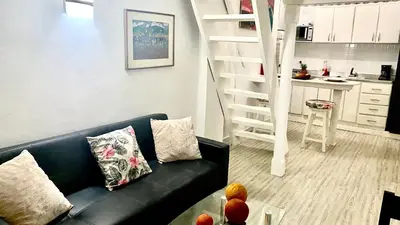 a living room with a black couch and a spiral staircase at Apartment in Old City Cartagena 3D in Cartagena de Indias