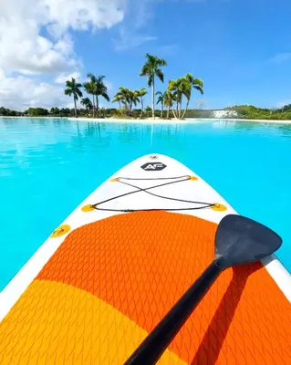 an orange and white kayak in the water with a paddle at Baia Kristal Penthouse Cartagena Playa Artificial Más Grande de Colombia in Cartagena de Indias