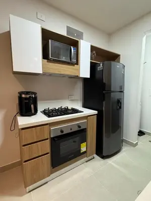 a kitchen with a stove and a refrigerator at Baia Kristal Penthouse Cartagena Playa Artificial Más Grande de Colombia in Cartagena de Indias
