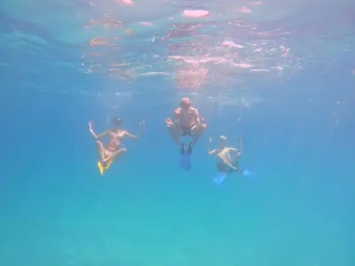 three men are swimming in the water at CARDUMEN ARTE y COCINA in Cartagena de Indias