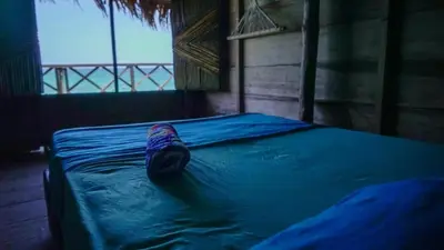 a bed in a room with a blue sheet at CARDUMEN ARTE y COCINA in Cartagena de Indias